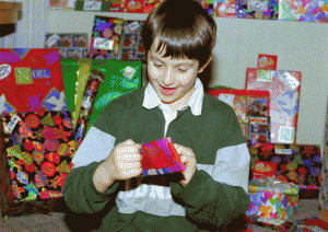 Tom enthusiastically opening one of his presents at Disneyland in 1998