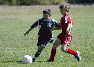 Stevie holding off a defender on the opposing team.