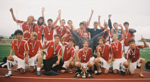 Soccer again, but you'll notice that they are getting bigger! Tom is our biggest, and this Under 19 team, which won the local District Cup, was full of big boys. Tom was younger than most. Here they are all celebrating the tournament win, with Tom behind the outstretched right hand of the assistant coach in the middle.
