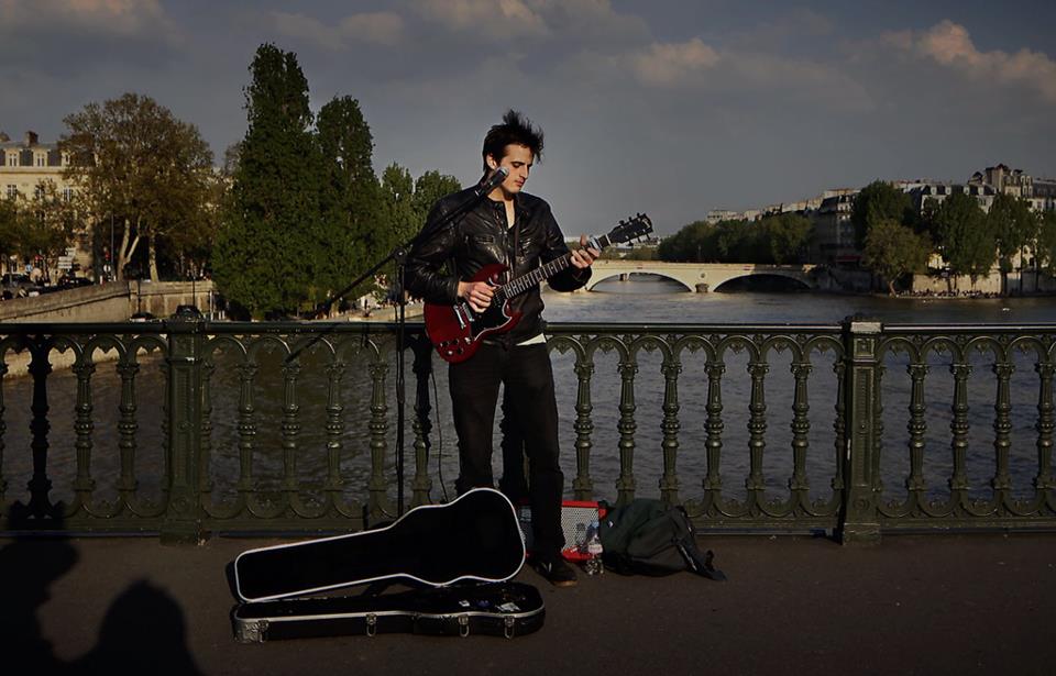 Tom busking on a bridge over the Seine. You too can suffer the privations of being a struggling young musician in Paris.